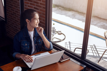 Young woman sitting at coffee shop and  seeing out side windows.