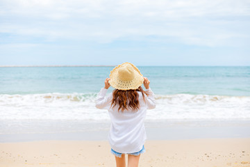 Fototapeta na wymiar young woman in sun hat on the beach. summer, holidays, vacation, travel concept