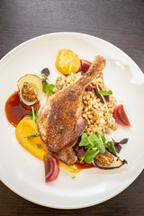 Grilled duck leg with pearls, vegetables, onions