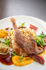 Grilled duck leg with pearls, vegetables, onions