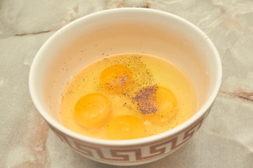 development of eggs in a plate with pepper four pieces of yolk on a marble table