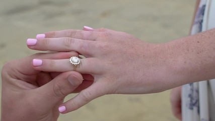 Man putting on ring of females hand, engagement