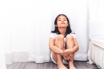 Obraz premium Neglected lonely child against the white wall. Little girl crying in the corner. Violence concept.