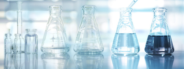 glass flask and vial set medical health research science blue laboratory equipment and water...