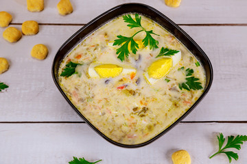 Creamy chicken soup with egg and crackers.