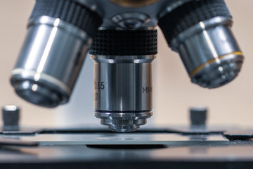 Close up of examining of test sample under the microscope in laboratory.