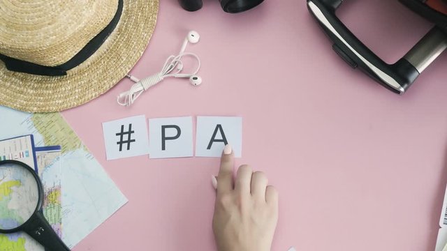 Top view hands laying on pink desk word PARIS