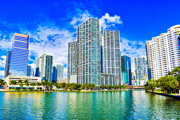 Brickell point and brickell key view with biscayne bay at downtown Miami Florida, blue sky, palm trees, art deco buildings reflecting on turquoise water, skyline by sunny day, financial district