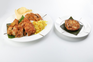 Traditional Malaysian Indian food white rice cabbage vegetable meat deep fried chopped chicken leg topped up with spicy mix gravy white background