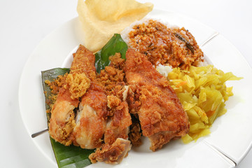 Traditional Malaysian Indian food white rice cabbage vegetable meat deep fried chopped chicken leg topped up with spicy mix gravy white background