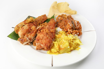 Traditional Malaysian Indian food white rice cabbage vegetable meat deep fried chopped chicken leg topped up with spicy mix gravy white background