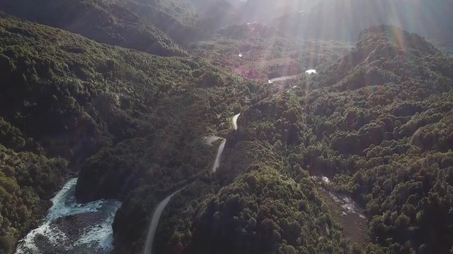 Picturesque Landscape of Chilean Andes. Road, River Canyon and Forest Hills Under Evening Sunlight Backlight