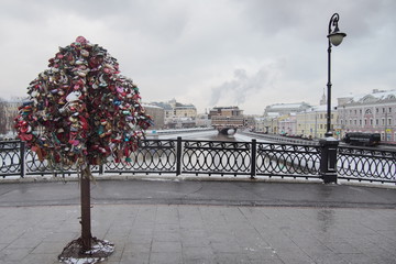 Wedding traditions, symbol of love and fidelity, honeymoon, Valentine's Day, engagement. Metal tree with locks on a bridge over the Moscow River. Vintage city panorama with pillars and cast-iron fence