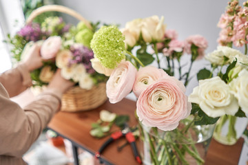 Education in the school of floristry. Master class on making bouquets. Summer bouquet in a wicker basket.. Learning flower arranging, making beautiful bouquets with your own hands. Flowers delivery