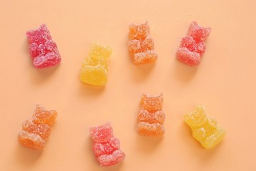 Gummy Bears  Candy. Fruit Bears jelly in sugar background.Candy pattern. Orange, red and yellow...