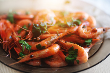 Delicious prawns with coriander in a plate on the table. Fresh seafood dish close-up