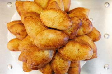 Fresh pastry. A lot of browned pies are on a platter in the dining room