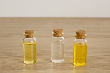 Transparent bottles of almond oil, jojoba oil and rose water for the production of natural environmentally friendly home cosmetics