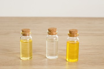 Transparent bottles of almond oil, jojoba oil and rose water for the production of natural environmentally friendly home cosmetics