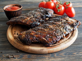 Beer in a white clay mug and traditional snacks on a rustic table - grilled ribs, slices of baked potatoes, sauerkraut. German cuisine.