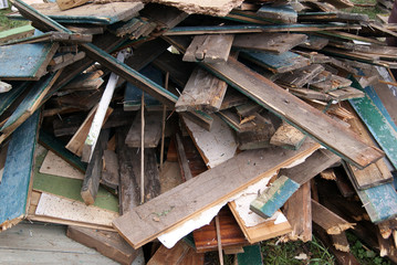 A pile of old boards with paint residue and nails sticking out
