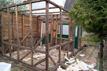 Fototapeta na wymiar Dismantling of an old wooden summer house in the country. Wooden frame