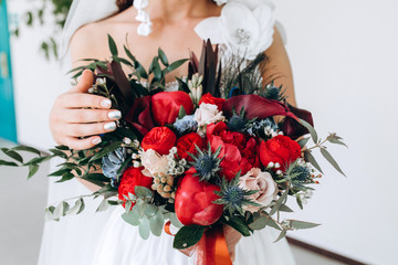 The bride holds a bouquet of roses. Beautiful wedding bouquet. The morning of the bride.