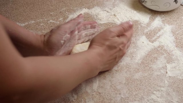 Woman's hands roll out pastry for making home made cake. Top view.