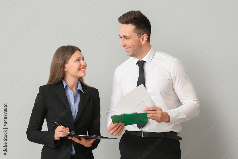 Poster Businesswoman and her male secretary on light background