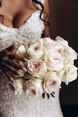 The bride holds a bouquet of roses. Beautiful wedding bouquet. The morning of the bride.