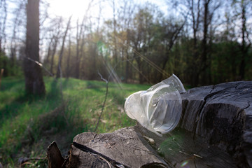 Broken disposable cup on the nature in the park. environmental pollution. eco friendly concept. non-degradable debris. Sun flare.