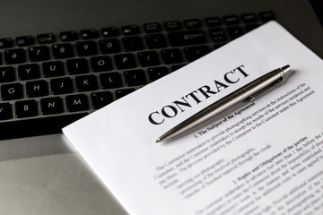 Pen for signing the contract. The pen and contract are on the laptop.