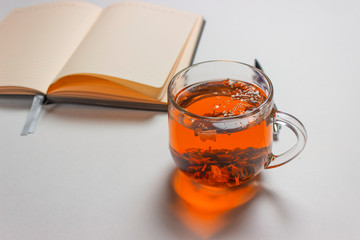 Tea in a glass and Notepad on a white background