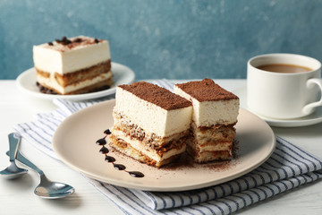 Composition with tasty tiramisu and cocoa drink on white wooden table. Delicious dessert