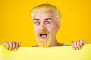 Funny man holding empty blank paper board with copy space for text.
