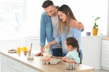 Happy family making dough together in kitchen