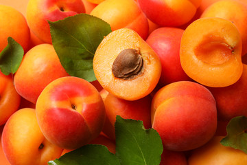 Tasty apricots and leaves on whole background, close up