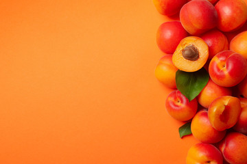 Fresh tasty apricots on orange background, top view