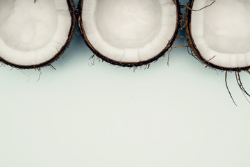 Parts of coconut on a colored background. Close up. Fresh ripe coconut broken into pieces.