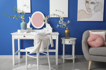 Interior of living room with stylish mirror and spring flowers