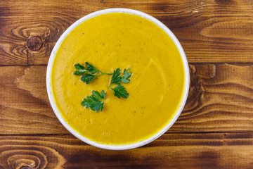 Pumpkin soup on a wooden table. Top view