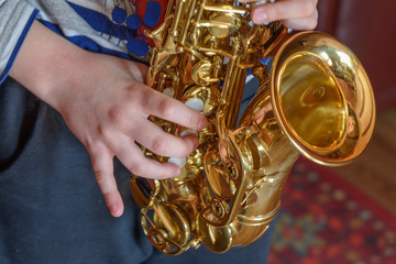 A boy learns a piece on the Piccolo saxophone