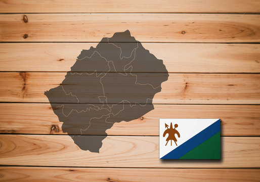 Map and flag of Lesotho on a wooden background.