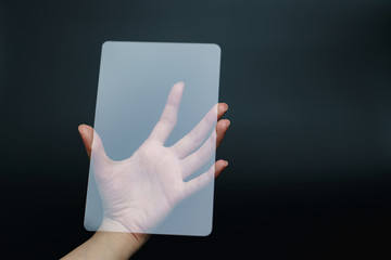 Hand holding and showing transparent tablet device. Business, technology concept.
