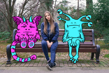 A girl with long hair is sitting and sad on a Park bench with her imaginary monster friends. Drawing on top of the photo