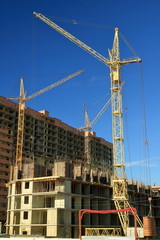 Tower cranes are working on the construction of a new house. Lifting crane.