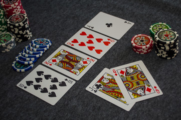 playing cards and poker chips on grey background