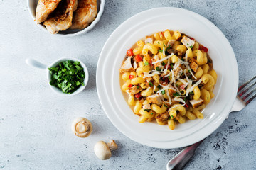 Roasted chicken mushroom pepper pasta in a white plate