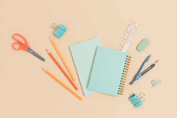 Layout of various stationery and copybooks on a beige background. Back to school concept.