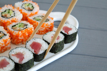 Japanese food sushi set with chopsticks close up on the gray wooden table